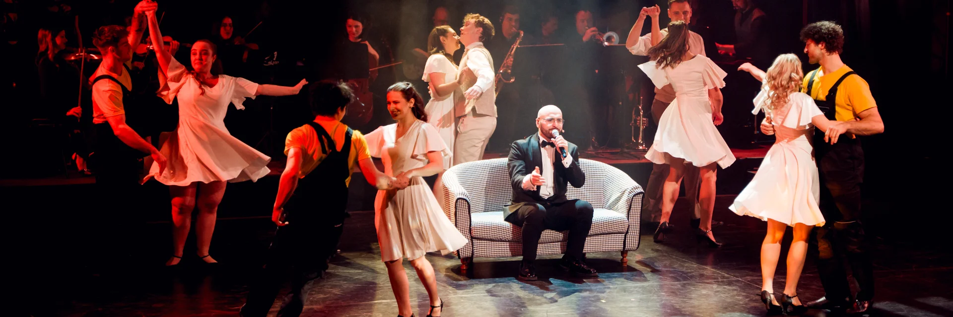 Fragment sceny choreograficznej. Na scenie śpiewa Artur Caturian.